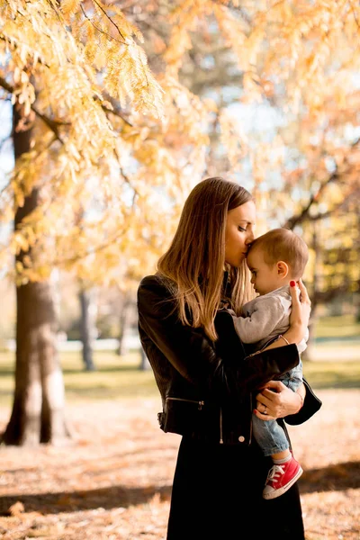 Gelukkige jonge ouders met babyjongen in herfst park — Stockfoto