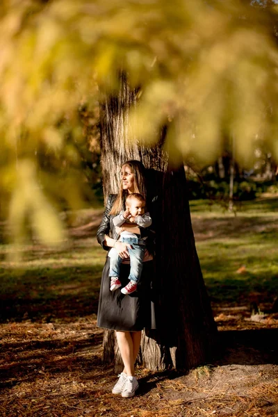 Jeune mère et bébé garçon dans le parc d'automne — Photo