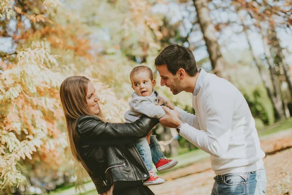 Familia feliz con el niño en el parque de otoño — Foto de Stock