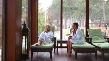 Genç ve güzel kadınlar tarafından kış günü kapalı yüzme havuzunda şezlonglar rahatlatıcı