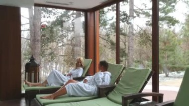 Genç ve güzel kadınlar tarafından kış günü kapalı yüzme havuzunda şezlonglar rahatlatıcı