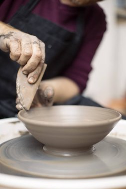 Sanatçı kil çömlek bir spin tekerlek üzerinde yapar.