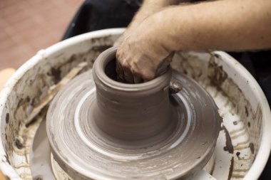 Sanatçı kil çömlek bir spin tekerlek üzerinde yapar.
