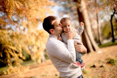 Genç Baba ve güneşli gün sonbahar parkta oynarken bebeğim