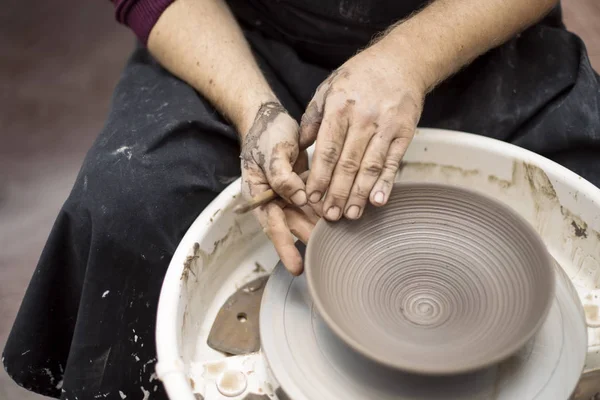 Artista hace cerámica de arcilla en una rueda giratoria — Foto de Stock
