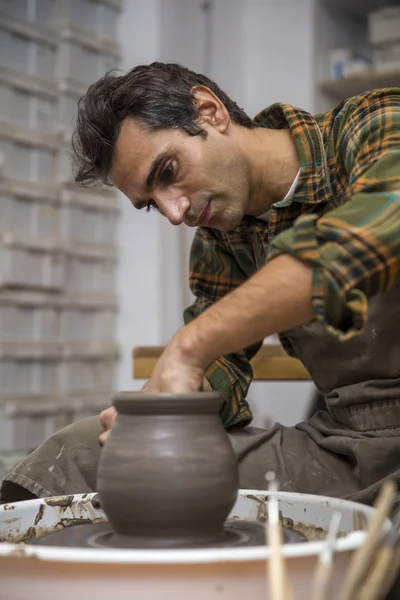 Artist makes clay pottery on a spin wheel in workshop — Stock Photo, Image