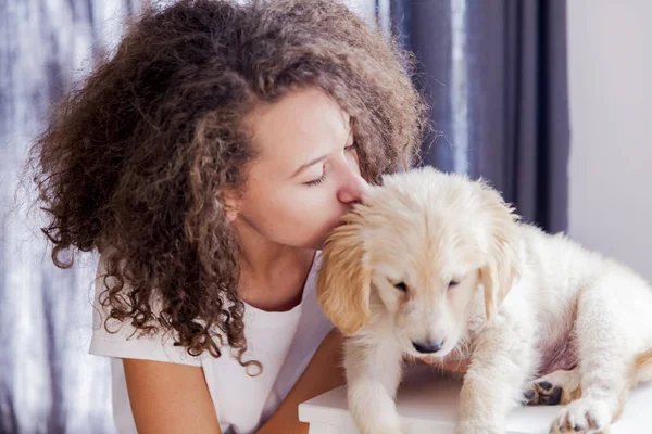 Genç kız ile küçük bir golden retriever — Stok fotoğraf