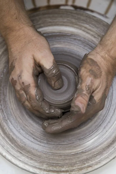 Artista hace cerámica de arcilla en una rueda giratoria — Foto de Stock