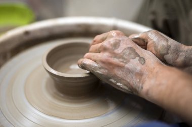 Sanatçı kil çömlek bir spin tekerlek üzerinde yapar.