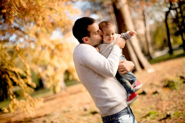 Mladý otec a spirálka v podzimním parku — Stock fotografie