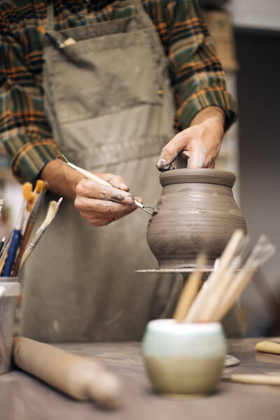 Young man making pottery in workshop