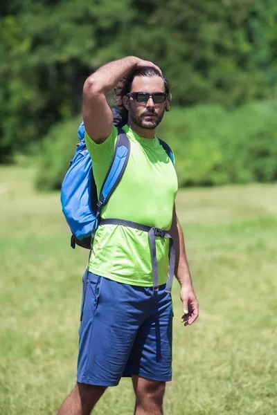 Giovane uomo escursioni nella natura verde — Foto Stock