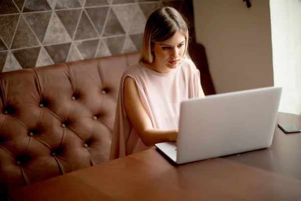 咖啡厅在笔记本电脑上工作的年轻漂亮的女人 — 图库照片
