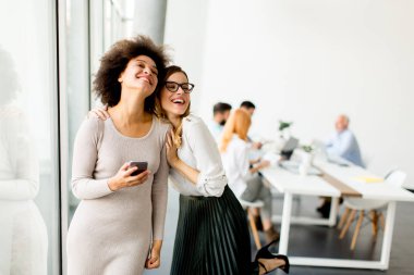 Ofis mobilya telefon ile genç ve güzel çok ırklı kadınlar