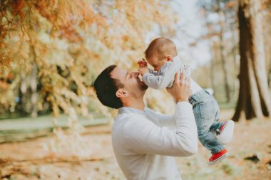 Genç Baba ve güneşli gün sonbahar parkta oynarken bebeğim