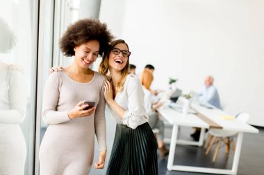 Ofis mobilya telefon ile genç ve güzel çok ırklı kadınlar