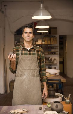 Yakışıklı genç tutan kil çömlek atölyesinde portresi