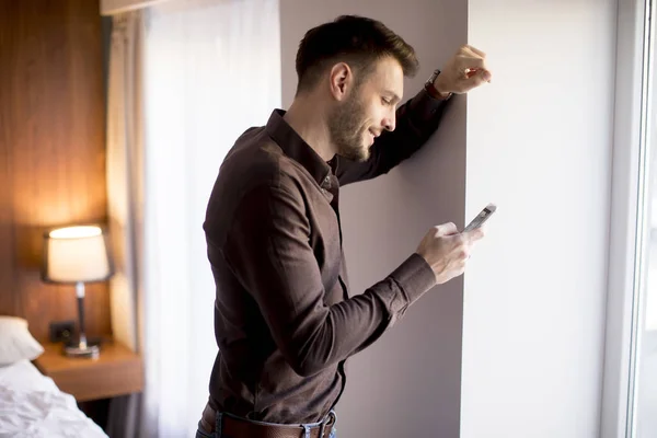 Jeune Homme Affaires Avec Téléphone Portable Par Fenêtre Dans Appartement — Photo