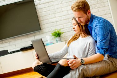 Sevgi dolu çift Oda ve dizüstü bilgisayarda web sörf internet katta oturan