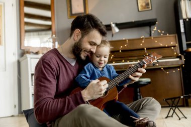 Baba öğretim kız evde odada gitar çalmayı