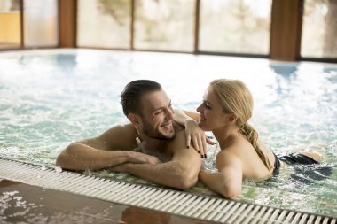 Çift spa merkezi havuzunda rahatlatıcı sevgi dolu