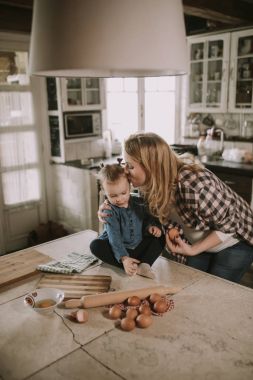 Hamile kadın ve küçük kızı rustik mutfakta yemek hazırlama
