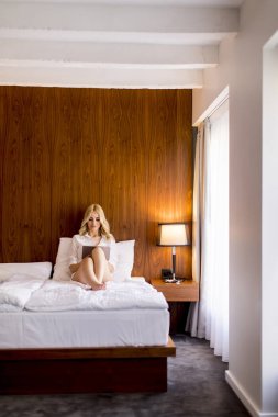 Sarışın genç kadın yatak odasında dijital tablet kullanma