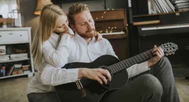 Adam genç güzel kadını için akustik gitar çalmak