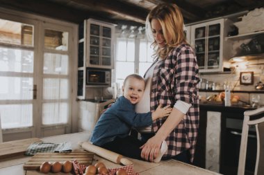 Hamile kadın ve küçük kızı rustik mutfakta yemek hazırlama