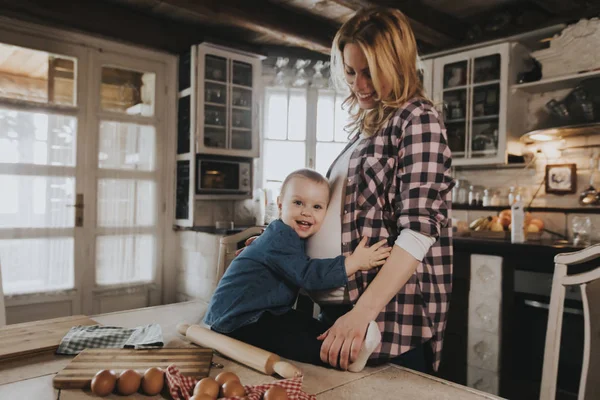 Hamile kadın ve küçük kızı rustik mutfakta yemek hazırlama