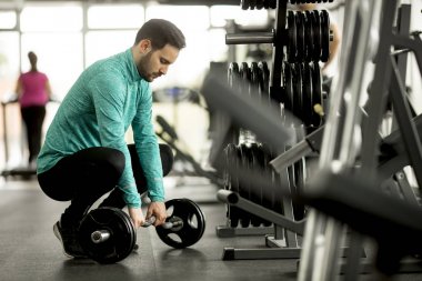 Yakışıklı genç spor salonunda egzersiz için hazırlar