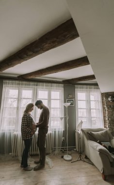 Genç adam ve hamile kadın evde Oda sarılma