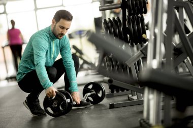 Yakışıklı genç spor salonunda egzersiz için hazırlar