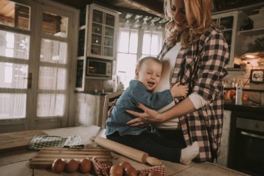 Hamile kadın ve küçük kızı rustik mutfakta yemek hazırlama