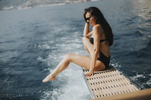 美丽的年轻女子在阳光灿烂的日子在海上的游艇上休息 — 图库照片