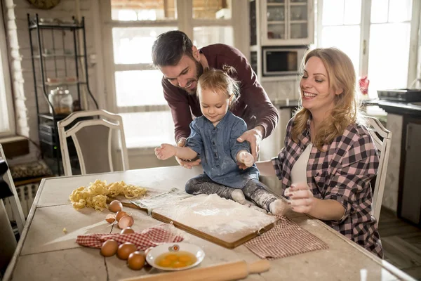 Happy family making pasta in the kitchen at home