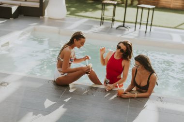 Kokteyl içme ve eğlenmek Yüzme Havuzu tarafından sıcak yaz gününde genç kadın
