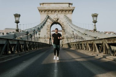Zincir köprü üzerinde gün Budapeşte, Macaristan'da koşan genç adam