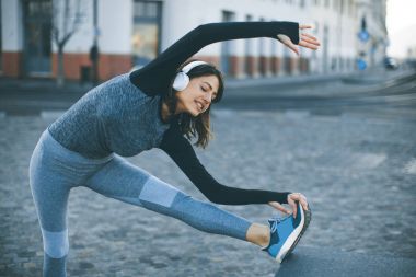 Genç kadın uygulamaları açık koşu sonra germe, görüntüleme