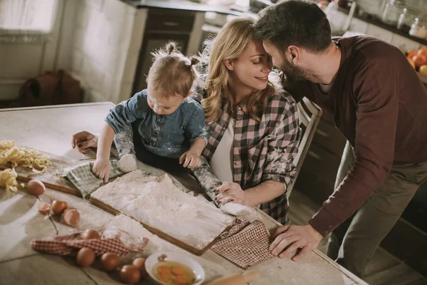 Happy family making pasta in the kitchen at home