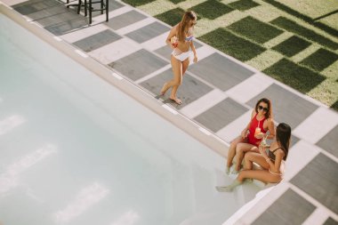 Kokteyl içme ve eğlenmek Yüzme Havuzu tarafından sıcak yaz gününde genç kadın