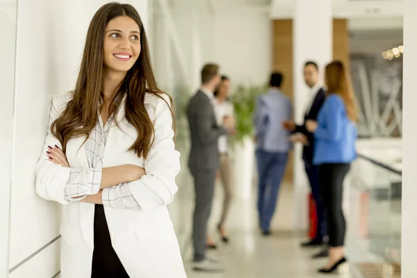 Jonge Zakenvrouw Staan Het Bureau Andere Jonge Zakenlui Praten Achtergrond — Stockfoto