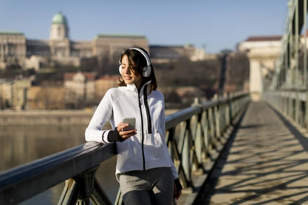 Kvinna Bron Att Göra Paus Och Lyssna Musik Efter Träningen — Stockfoto