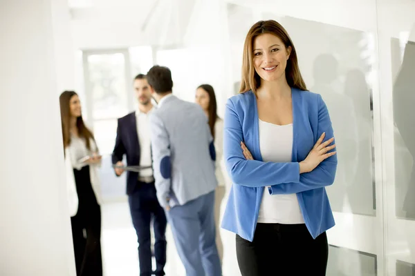 Junge Geschäftsfrau Steht Büro Und Andere Junge Geschäftsleute Reden Hintergrund — Stockfoto