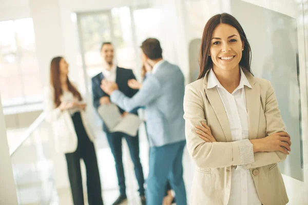 Junge Geschäftsfrau Steht Büro Und Andere Junge Geschäftsleute Reden Hintergrund — Stockfoto