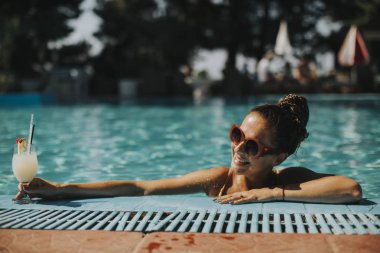 Genç ve güzel kadın kokteyl ile Yüzme Havuzu tarafından