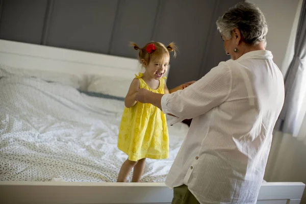Mormor Leker Med Ett Litet Barnbarn Sängen Rummet — Stockfoto