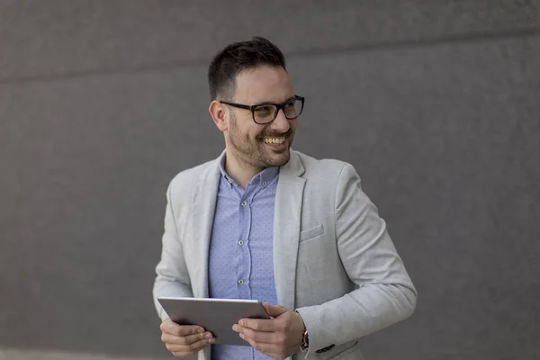 Stilig Ung Affärsman Med Digital Tablett Den Grå Väggen — Stockfoto