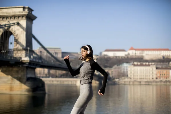 Woman in sportswear running on Danube river promenade in Budapest, Hungary