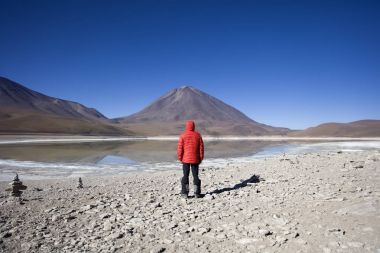 Genç adam Laguna Verde göl ve Reserva Nacional de Fauna Andina Eduardo Avaroa Bolivya'nın Licancabur yanardağ bakarak